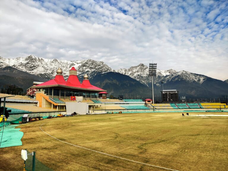 Scenic view of Dharamshala Cricket Stadium against stunning snow-capped mountains in Himachal Pradesh, India.