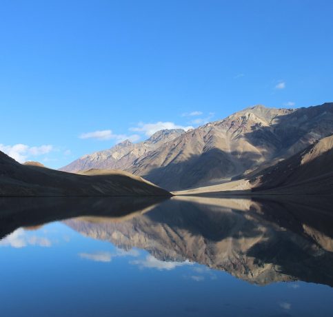 Discover Himachal Manali taxi service for Manali, Spiti & Ladakh tours." Crystal-clear waters of Chandratal Lake reflecting the majestic Himalayan peaks.